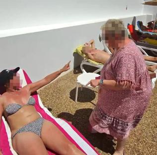 Screenshot of a poolside argument between two women over sunbeds.