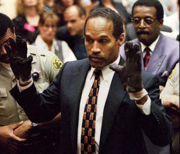 O.J. Simpson in court, wearing blood-stained gloves.