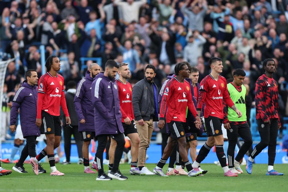 Manchester United players and staff leaving the field after a game.