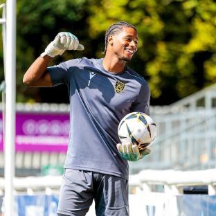 Soccer goalie holding a ball and celebrating.