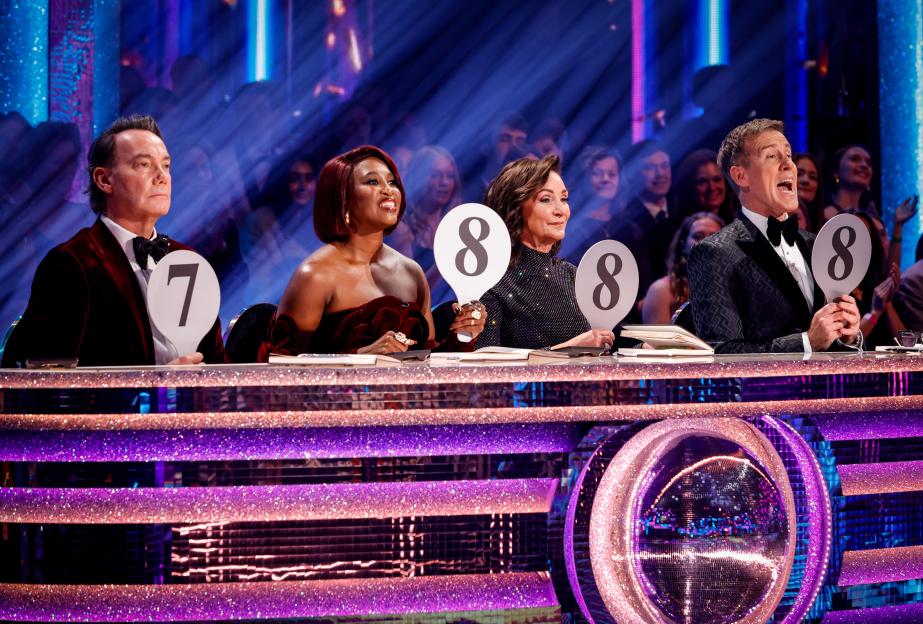 Four judges holding up score paddles (7, 8, 8, 8) at a dance competition.