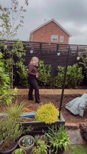 Pregnant woman standing in her garden.