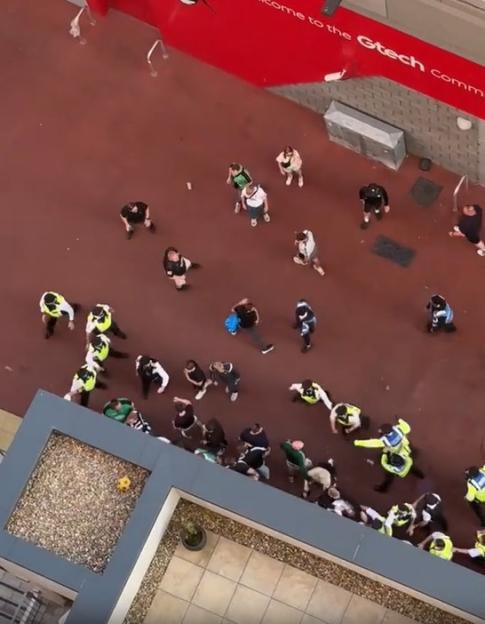 Aerial view of police officers detaining a group of people.