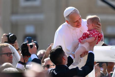 Pope Leo XIV holding a baby.