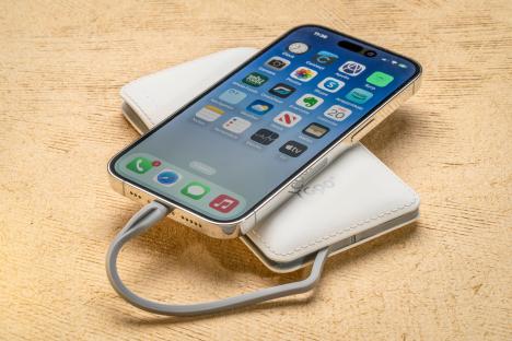 iPhone 14 Pro charging on a portable battery pack.