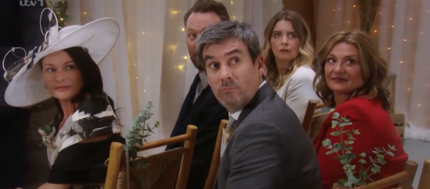 Screenshot of wedding guests sitting in chairs.