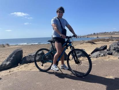 Man with bicycle on beach.