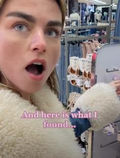 A woman in a Primark store comparing her jewelry designs to similar rings on display.