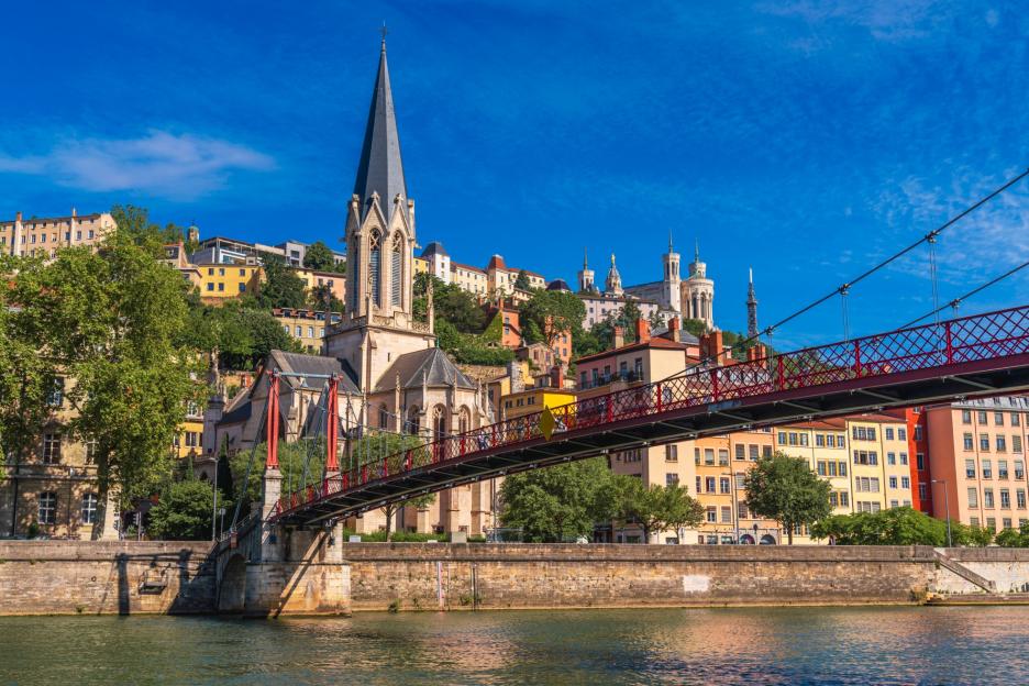 View of Lyon, France, with a church, bridge, and cityscape along the waterfront.