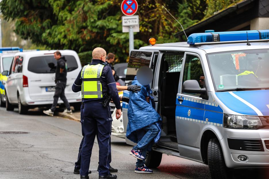 Police officers bringing a teenager to a police car in Herdecke.