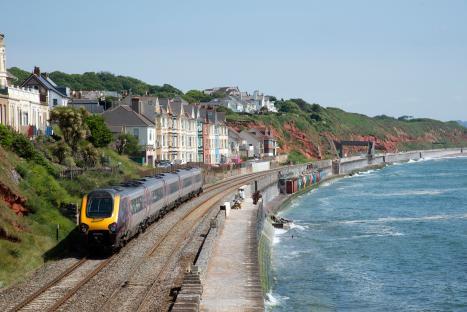 Passenger train traveling along a coastal railway.