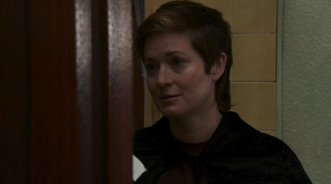 A woman with short brown hair gazes to her left.