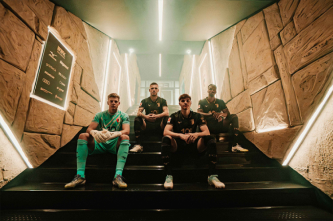 Four soccer players sitting on stairs.
