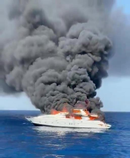 Burning yacht sinking in the ocean.
