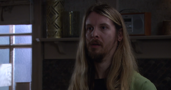 Screenshot of a man with long blond hair.