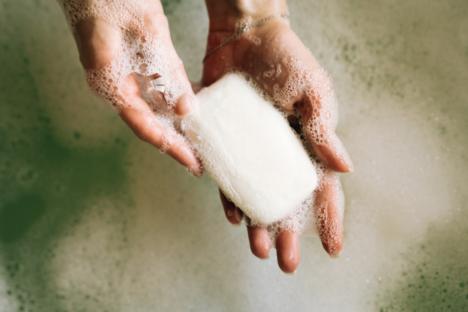 Hands washing with soap in a bubble bath.