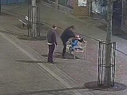 Screengrab showing two people damaging a Paddington Bear statue.