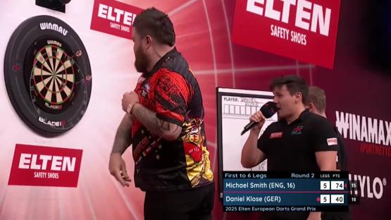 Michael Smith breaking a dartboard after a darts match.