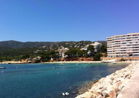 Portals Nous, Majorca: a beach with turquoise water, boats, and buildings on a hillside.