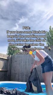 Person placing black trash bags in a paddling pool to cool the water.