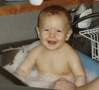 a baby is taking a bath in a sink and smiling .