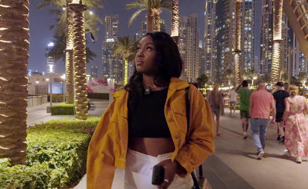 Woman walking in Dubai at night.