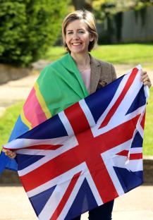 A woman holds a UK flag and a Pride flag.