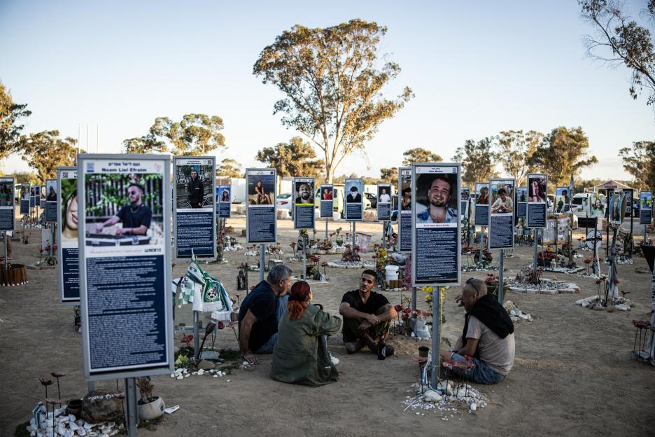 A family sits at a memorial for victims of the 2023 October 7 attacks at the Nova Festival grounds.