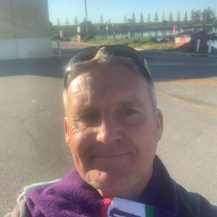 Selfie of a man wearing sunglasses and a purple scarf.