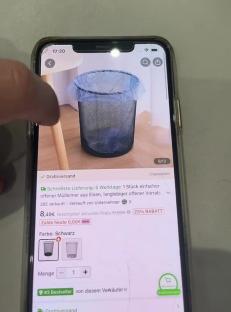 Smartphone screen showing a product listing for a black metal trash can.