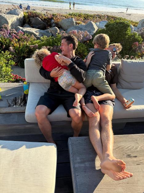 Orlando Bloom with his two children on a couch.
