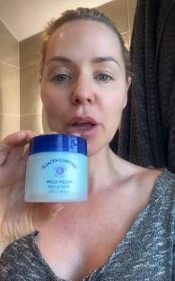 Woman holding jar of Nutrientials Pillow Glow sleeping mask.