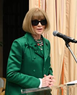 Anna Wintour speaking at a podium.