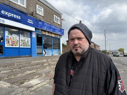 Man expressing concern about safety near a post office and fish bar.