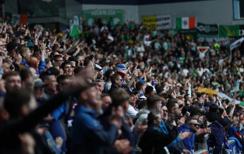 Rangers fans cheering in stadium stands.