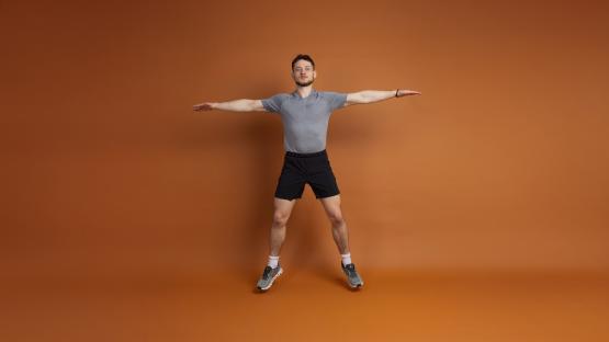 Man performing a jumping jack exercise.