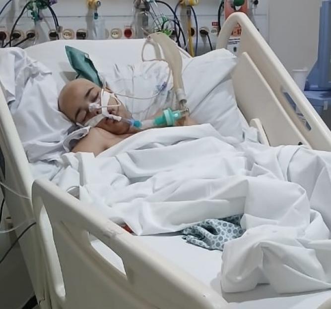 Woman in hospital bed receiving oxygen.