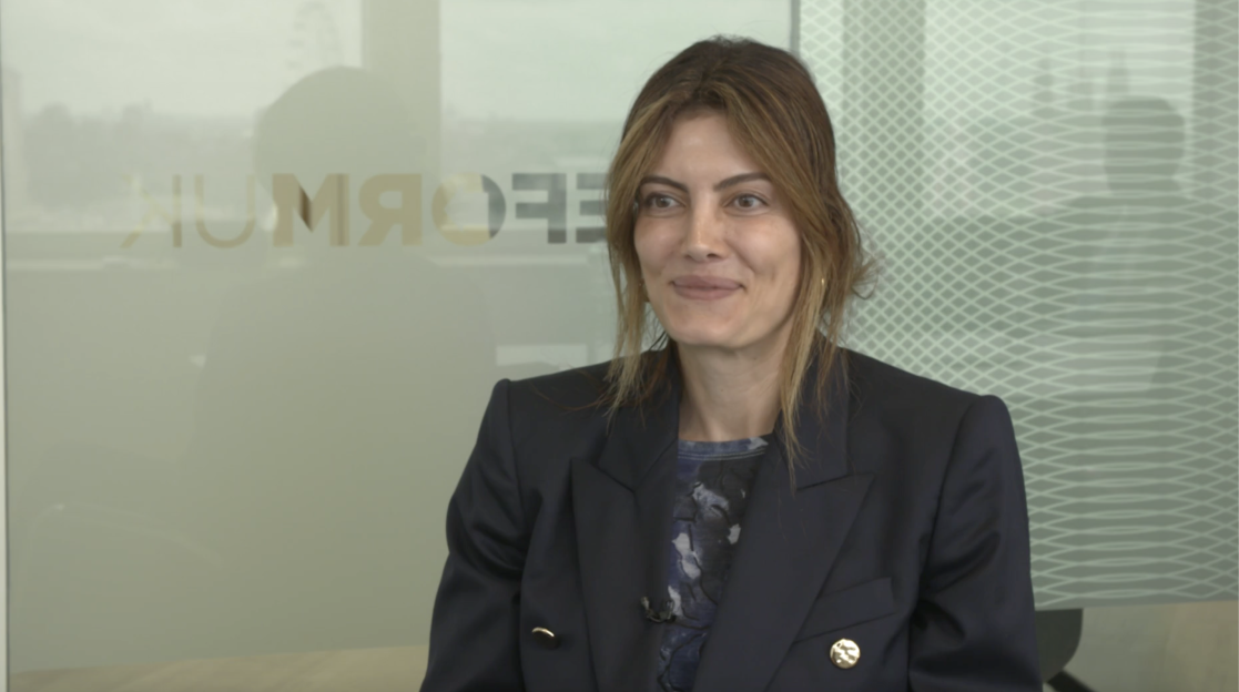 Woman in a dark blazer smiling.