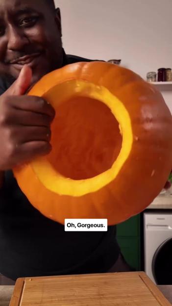 A person holding a hollowed-out pumpkin with the words "Oh, Gorgeous." on the image.
