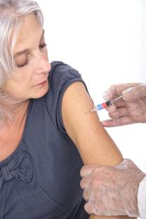 A mature woman receiving a vaccination.