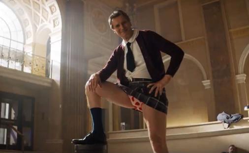 Liam Neeson in a schoolgirl costume for a movie trailer.