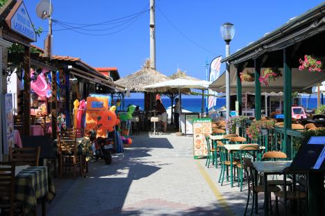 Greek island street scene with restaurants and shops.