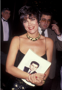 Woman in black dress holding a photo of a man.