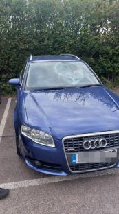 Blue car with shattered windshield.