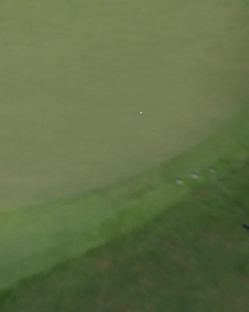 Rory McIlroy making a trick shot on a golf course.