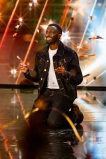 Joseph Charm, contestant on Britain's Got Talent, kneeling on stage after receiving a Golden Buzzer.