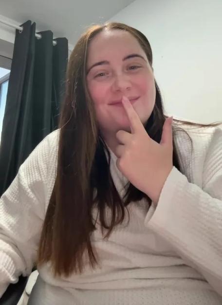 Woman smiling and touching her nose.