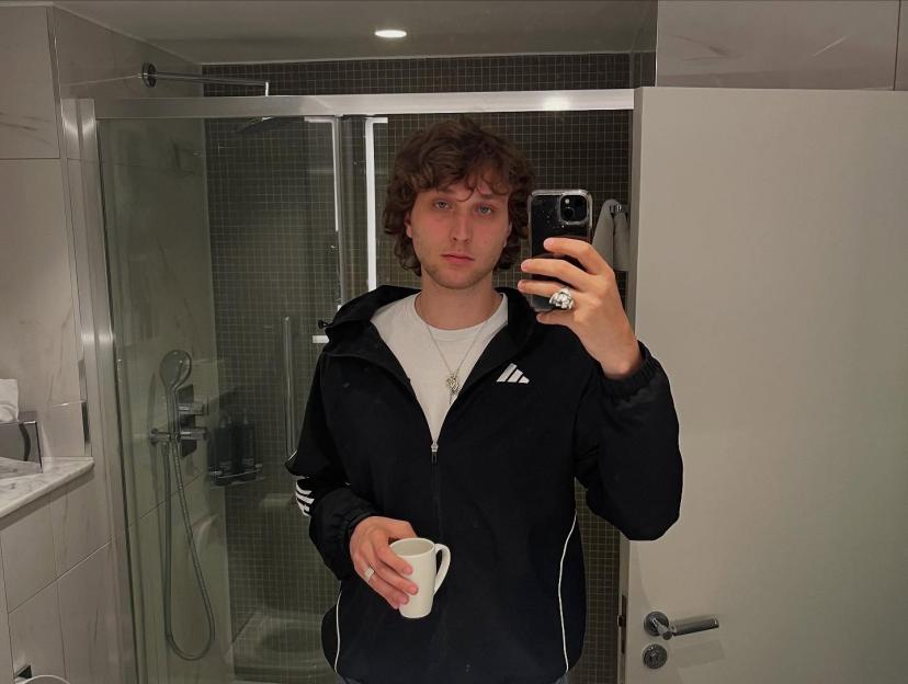 Ronan Day-Lewis holding a coffee cup and taking a selfie.