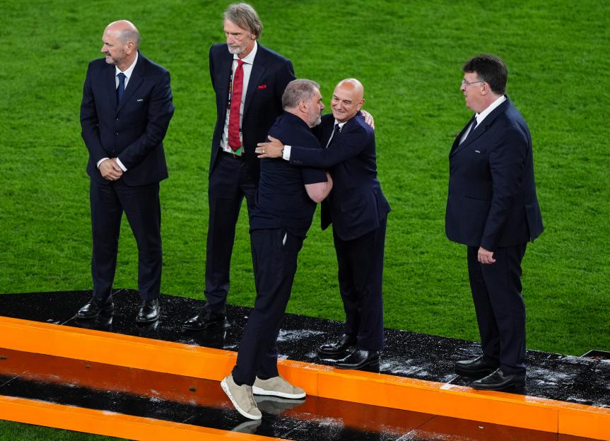 Ange Postecoglou and Daniel Levy embracing, with other officials present.