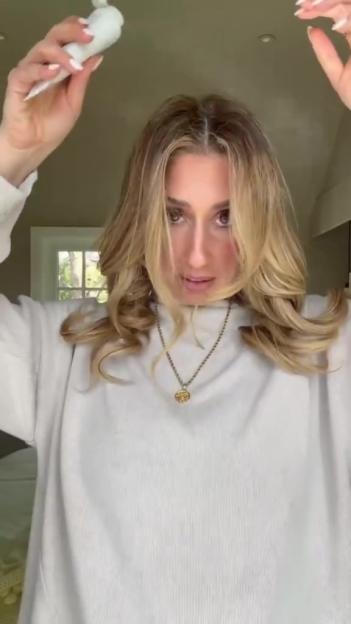 Woman applying a product to her hair.